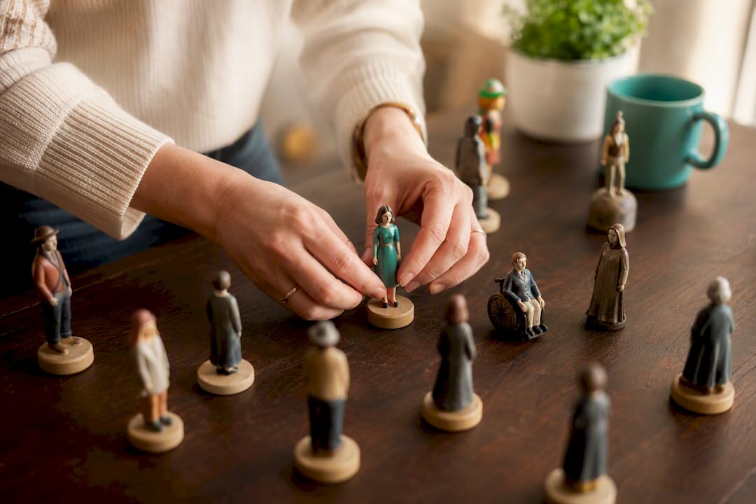 Des mains retirent une silhouette emblématique d’un groupe, symbolisant l'exclusion ou la séparation.